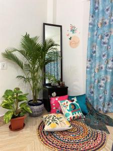 西里古里Bhuman Homestay的一间设有植物、镜子和枕头的客房