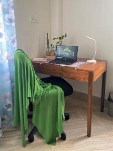 西里古里Bhuman Homestay的一张木桌,椅子上配有一台笔记本电脑
