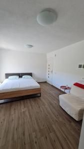格雷巴蒂卡Apartmani Mlinar - studio apartment的一间卧室设有两张床,铺有木地板