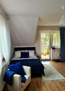 下乌斯奇基Apartament Katarina 2的一间卧室配有一张床和一张带蓝色枕头的沙发