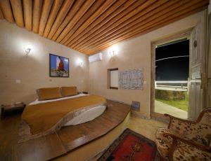 乌奇希萨尔Karlık Cave Suite Cappadocia的一间卧室设有一张木天花板床。