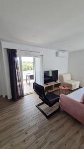 格雷巴蒂卡Apartmani Mlinar - One bedroom apartment with seaview的客厅配有椅子、沙发和桌子