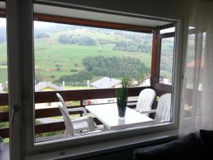 萨沃宁Tgesa Tgampi T20的客房设有带桌子和白色椅子的窗户。