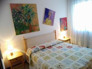 卡奥莱B&B Cà d'Artisti的卧室配有一张床,墙上挂有绘画作品