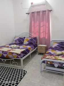 珍南海滩Safiyya Homestay的一间卧室设有两张床和窗户。