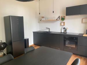 KortessemHuis Louis的厨房配有黑色橱柜、水槽和桌子