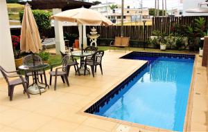卡舒埃拉保利斯塔Hotel Água Viva - By UP Hotel的一个带桌椅和遮阳伞的游泳池