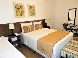 卡舒埃拉保利斯塔Hotel Água Viva - By UP Hotel的酒店客房,设有两张床和镜子