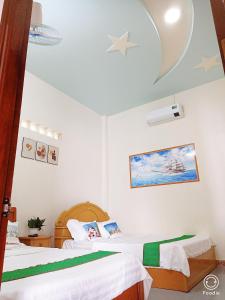 Hiếu XươngNoel Homestay的一间卧室设有两张床,天花板拥有星星。