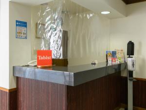 磐田市Tabist IWATA Station Hotel的墙上有塑料包裹的柜台