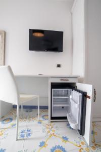 斯卡拉CASA ALBA D'ORO的厨房配有开放式冰箱和椅子