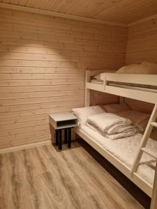BrygghaugenOff-the-grid cabin on the island of Senja in northern Norway的客房设有两张双层床和一张书桌。