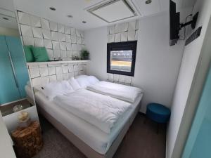 不来梅港Hausboot Lobster Bremerhaven的一个小房间的小床,设有窗户