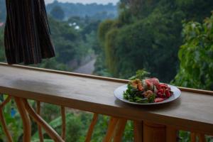 TzununáBambu Guest House的坐在阳台上的栏杆上的食物