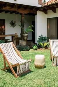 危地马拉安地瓜Casi Casa的院子里放着几把椅子和一块石头