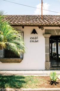 危地马拉安地瓜Casi Casa的白色的建筑,上面有读出撒拉沙的标志