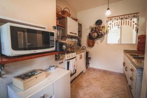 兰舒凯马杜Casa Fuchsia Régia em Rancho Queimado/SC的厨房配有微波炉和炉灶。