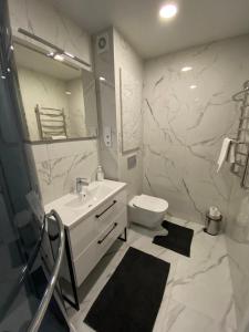 斯米尔泰内Feelings Apartment apartamenti Smiltene的白色的浴室设有水槽和卫生间。