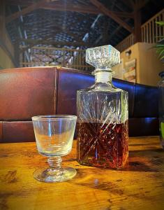 伯里亚Nicura Ranch Inn & Stables的一瓶威士忌和一张桌子上的一杯