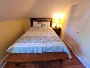 South KortrightThe Hidden Inn的一间卧室配有一张带木制床头板的床