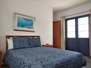 MáguezFinca La Tabaiba Apartamento alto的一间卧室配有一张带蓝色棉被的床和一扇门