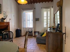 波克罗勒岛La Maison et son adorable jardin clos的客厅配有书桌、沙发和窗户。