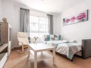 拉阿尔加瓦Apartamento con patio y piscina cerca de Sevilla的客厅配有床和沙发