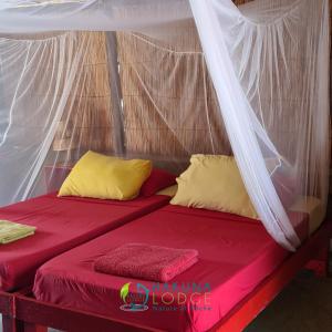 Mar LodjCampement Hakuna Lodge的帐篷内的一张床位,配有红色床单和黄色枕头