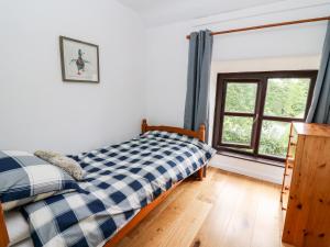 兰达西尔Fisherman's Cottage的一间卧室设有一张床和一个窗口