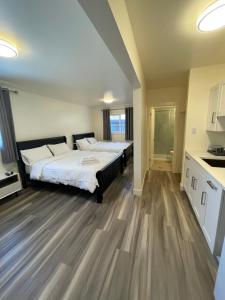 镭温泉Destination INN的一间卧室设有两张床,铺有木地板