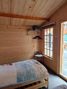 劳雷尔苏格Slaaphuisjes LauwersmeerPlezier!的小木屋卧室设有床和窗户
