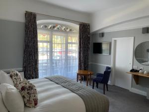 锡德茅斯Bedford Hotel的一间卧室配有一张床、一张桌子和一个窗户。