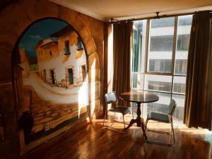 拉巴斯Terraza Hotel的客房设有桌椅和大窗户。