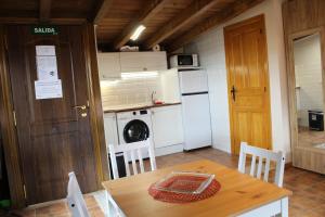 拉瓦斯蒂达Atico El Miraviñas的小厨房配有桌子、洗衣机和烘干机