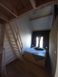 JurbisePourquoi pas Au Canard的一间卧室设有床、窗户和楼梯。