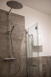 博尔戈马内罗Hotel San Francesco的浴室里设有玻璃门淋浴