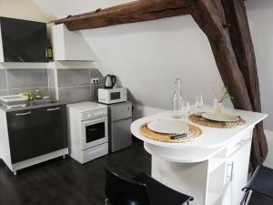 马尼库尔Appartement au pied du circuit de Magny-cours的厨房配有一张桌子和两个盘子