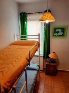 米拉弗洛迪拉希Casa Inma的一间卧室配有一张带绿窗帘和灯的床