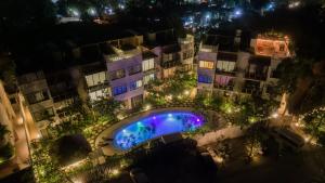 图卢姆Luxury Condos Macondo Tulum的享有大楼的顶部景色,晚上设有游泳池