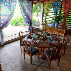 Santa María HuatulcoPlanta Glamp Farm的一间带桌椅和窗户的用餐室