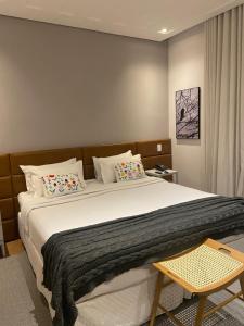 迪亚曼蒂纳Hotel Estilo de Minas的卧室配有带枕头的大型白色床