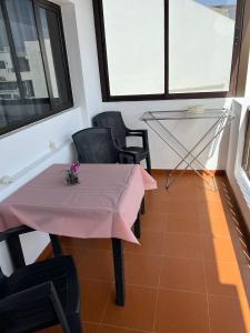 宏达海滩Casa La Orilla 2的窗户间里的粉红色桌子和椅子