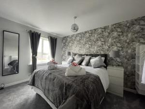 北安普敦Home From Home Northampton的一间卧室配有一张带花卉壁纸的大床