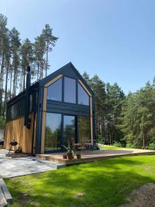 BorkówBrama do lasu - Domek Energia的现代房屋设有玻璃窗和草坪