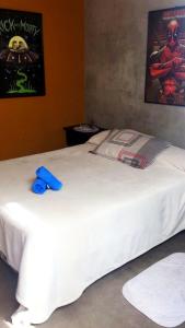 Hogar de Adriane Bed and breakfast cerca al aeropuerto的一张白色的床,上面有蓝色的物体