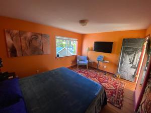 圣罗莎My Big Art Project的一间卧室设有橙色的墙壁、一张床和电视