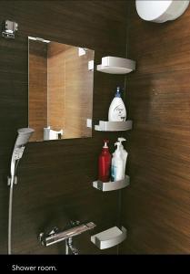 境港市Da Fern的浴室设有镜子、带肥皂和洗发水的盥洗池