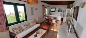拉奥罗塔瓦Casa en Finca Ecológica - Wifi的一间带白色沙发的客厅和一间厨房