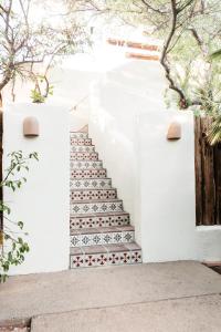 土桑The JTH Tucson的白色墙壁上铺有红白瓷砖的楼梯