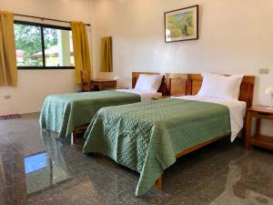 BanguedStrutz Art Garden Resort的酒店客房,配有两张带绿床单的床